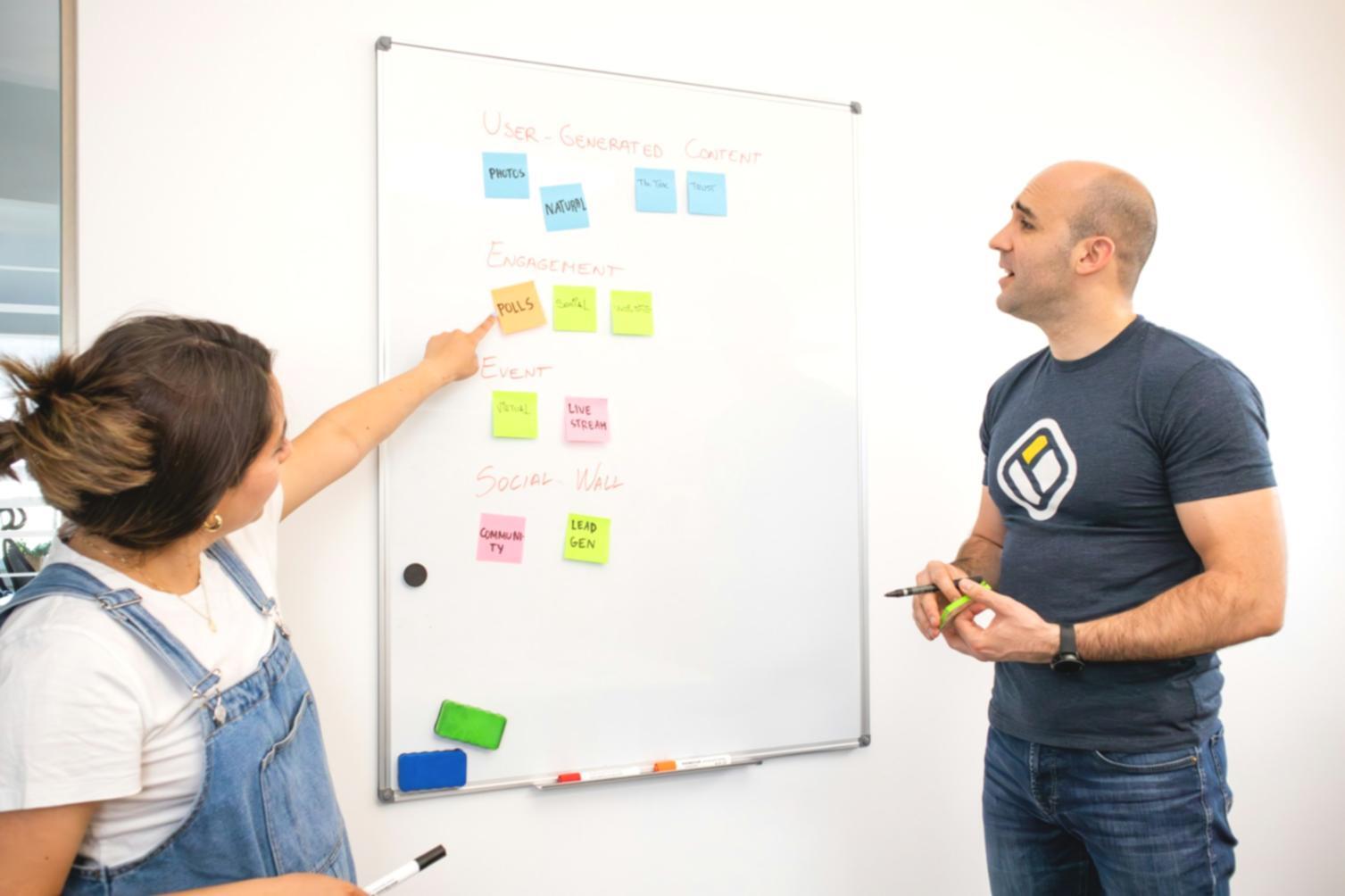 Team collaboration workspace showing content optimization analysis on multiple screens with team members discussing strategy